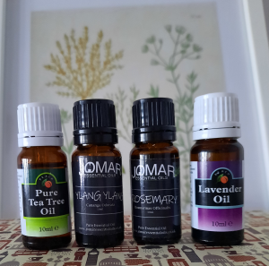 four essential oil bottles, ea tree, ylang, ylang, rosemary and lavender