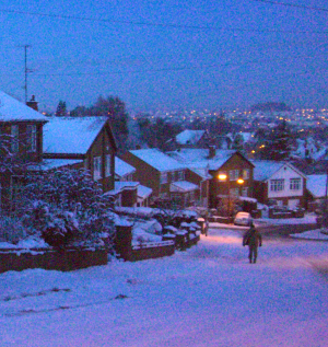 A snowy scene in a suburban street